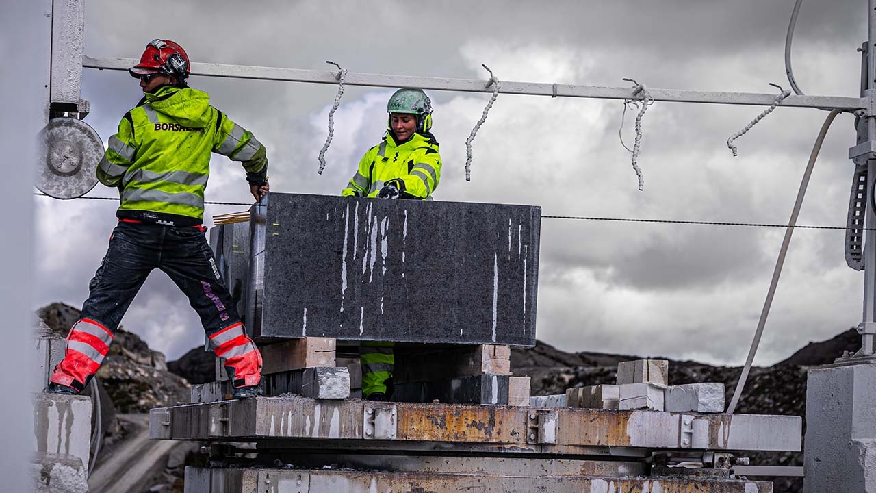 Bilde av to mennesker som opererer en blokksag.ererer en 